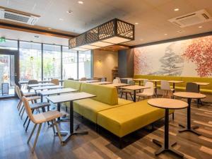 ein Restaurant mit Tischen und Stühlen in einem Raum in der Unterkunft Shizutetsu Hotel Prezio Kyoto Karasumaoike in Kyoto