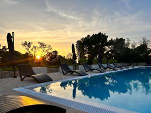 Una fila de sillas junto a una piscina. en Holiday Home Ahil 1, en Pakoštane