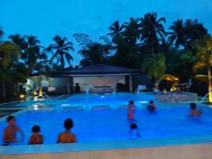 a group of people in a swimming pool at night at Malibhu View Resort in Carmen