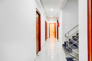 Un pasillo de una casa con paredes blancas y una escalera. en Hotel O JP Nagar Miyapur, en Lingampalli