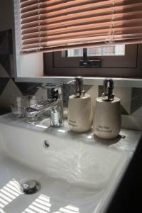 a bathroom sink with two soap dispensers on it at TH Villa, Vinhome Ocean Park, Hanoi in Hanoi +63 photos