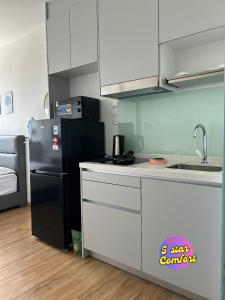 una cocina con nevera y armarios en blanco y negro en 5 Star Comfort Riveria City KL Sentral 4 pax infinity pool, en Kuala Lumpur 81 fotos más