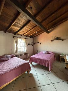a bedroom with two beds and a window at Entre el sol y la luna in Taxco de Alarcón