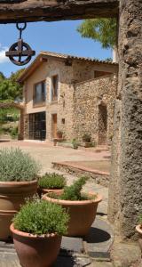 un edificio in pietra con piante in vaso di fronte ad esso di Mas Salvador Rural Experience a Llagostera