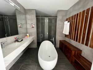 a bathroom with a large white tub and a shower at Beach villas ideal for families & groups to get together & retreat in Ấp Phước Tĩnh +5 photos