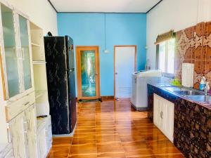 una cucina con pareti blu e pavimenti in legno di Busaba Villa Sea Views a Tha Sala Altre 83 foto
