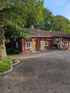 an old red barn with a tree in front of it at Drängstugan Bärsta 5 in Kolbäck