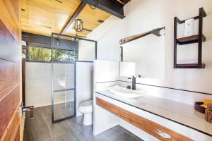 a bathroom with a sink and a glass shower at Casa Villa Real- Lagoon Acces And Stunning Views! in Bacalar