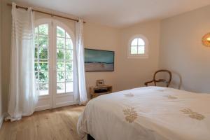 a bedroom with a bed and a large window at Villa Denise in Bidart