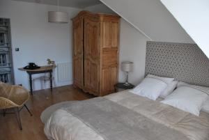 - une chambre avec un grand lit et une armoire en bois dans l'établissement Au Detour de Rennes, à Bruz