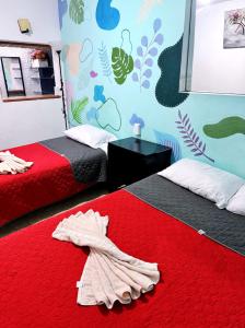 a bedroom with two beds and a red blanket at Casita del Árbol in Mexico City