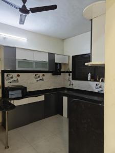 a kitchen with black and white cabinets and a ceiling at 3BHK Spacious Villa in Pune