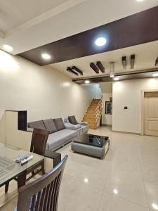 a living room with a couch and a table at 3BHK Spacious Villa in Pune
