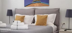 a bedroom with a bed with white and yellow pillows at Villa Ballerina Bianca in Scopello +41 photos