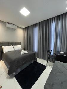 a bedroom with a bed and a television and curtains at Casa, 01 Suíte, Ar-Cond, Área Gourmet e Garagem Ampla in Montes Claros