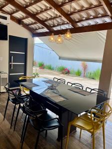 a dining room with a black table and chairs at Casa, 01 Suíte, Ar-Cond, Área Gourmet e Garagem Ampla in Montes Claros