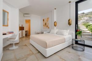 Un dormitorio blanco con una cama y un escritorio. en Villa Sorriso - Plaka Beach, Seaview, Pool, en Plaka 85 fotos más