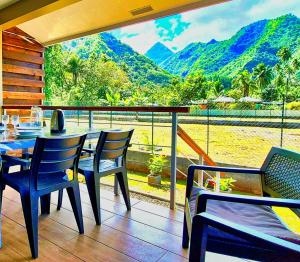 a restaurant with a table and chairs and a view of the mountains at Teahupo'o Lodge Tahiti - Studio Evasion - climatisé - entre randonnées et activités nautiques in Teahupoo