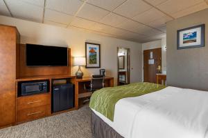 a hotel room with a bed and a flat screen tv at Comfort Inn & Suites Gateway to Glacier National Park in Shelby