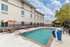 a pool at a hotel with tables and chairs at MainStay Suites Lancaster Dallas South in Lancaster