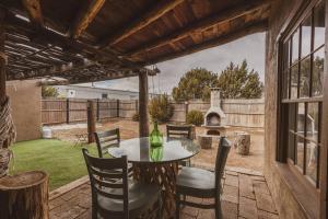 Un patio con mesa y sillas y una chimenea. en Casita Mistica A Southwest Adobe Field Home, en Nogal