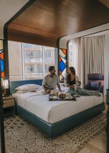 a man and woman sitting on a bed in a hotel room at Andaz Dubai The Palm, By Hyatt in Dubai