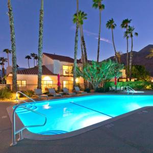 a swimming pool in front of a house with palm trees at Avocado Toast - Steps To Tennis, Pickleball, Golf in La Quinta