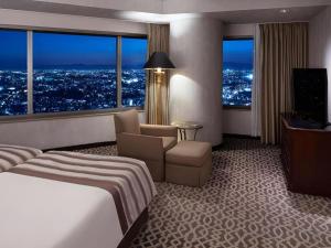 a hotel room with a bed and a television at Yokohama Royal Park Hotel in Yokohama
