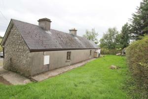an old stone house with a grass yard at Glenedagh Oughter B&B in Ballycastle