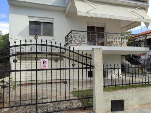 a black fence in front of a white house at Elena's Apartment in Nea Fokea +2 photos