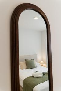 ein Schlafzimmer mit einem Bett mit einem großen Spiegel in der Unterkunft Calma & Beach Estepona Retreat in Estepona