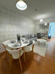 a living room with a table and a couch at Modern Oasis: Pool + Netflix in Manila