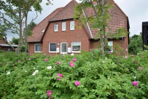 a house with pink flowers in front of it at Kommodig No. 3 in Garding