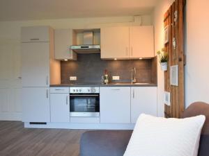 a kitchen with white cabinets and an oven at Kommodig No. 3 in Garding
