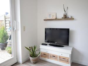 a flat screen tv sitting on top of a white cabinet at Kommodig No. 3 in Garding