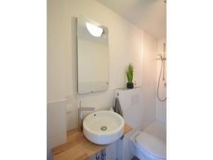 a white bathroom with a sink and a toilet at Kommodig No. 3 in Garding +10 photos