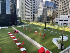 a group of tables and chairs on a field in a city at Queens Wharf 50th Floor in Brisbane