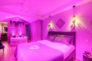 a pink bedroom with a bed and a tub at L'Essentiel - Love 5 Etoiles in Talmont