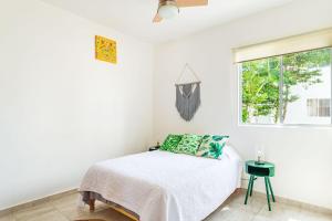 a white bedroom with a bed and a window at Lovely COZY Apt w/pool 2 Bedrooms. Great location! in Puerto Morelos