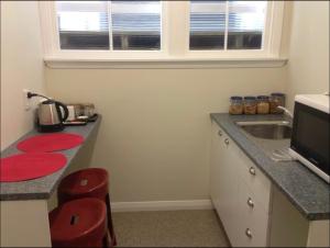 a kitchen with a counter with a sink and a microwave at Kelburn B&B in Wellington