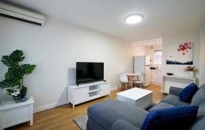a living room with a couch and a flat screen tv at Rivervale Cosy Stunner Sleeps 2 in Perth