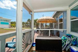 un porche con mesa y sombrilla en Great After Milton -pool & Waterfall! Beach! Im, en Englewood