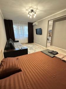 a hotel room with a large bed and a couch at Академика Сатпаева 36 in Pavlodar