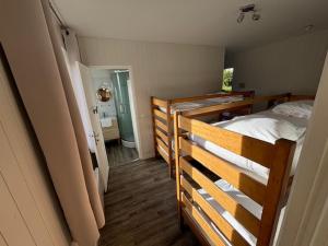 une chambre avec deux lits superposés et une salle de bain dans l'établissement Centre de Vacances CPCV Normandie à 50 metres de la plage de Houlgate, à Houlgate