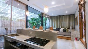 a kitchen with a sink and a living room at Kalino Villa by Betterplace in Canggu