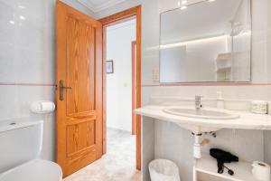 une salle de bain avec un lavabo, des toilettes et un miroir dans l'établissement Vistamar, à Bellreguart 14 autres photos