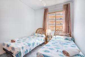 deux lits dans une chambre avec une fenêtre dans l'établissement Vistamar, à Bellreguart