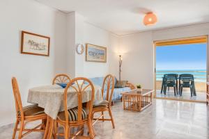une salle à manger avec une table et des chaises et l'océan dans l'établissement Vistamar, à Bellreguart