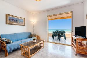 - un salon avec un canapé bleu et une vue sur l'océan dans l'établissement Vistamar, à Bellreguart