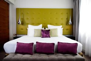 
a bed with a white comforter and pillows at K West Hotel & Spa in London
